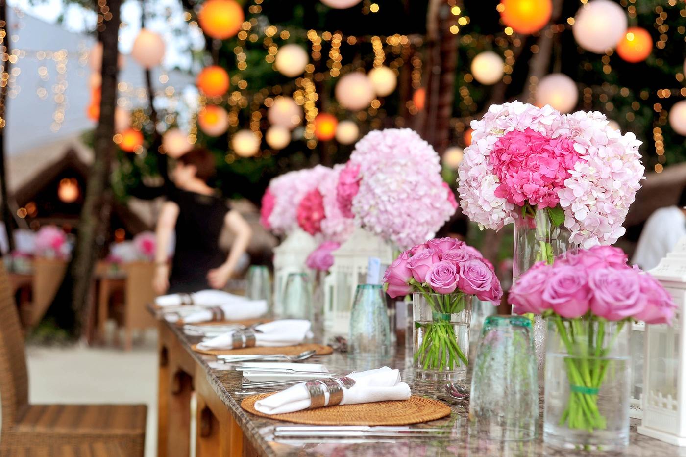 Table inside of marquee decorated for wedding in foreground, marquee lighting & decor in background.